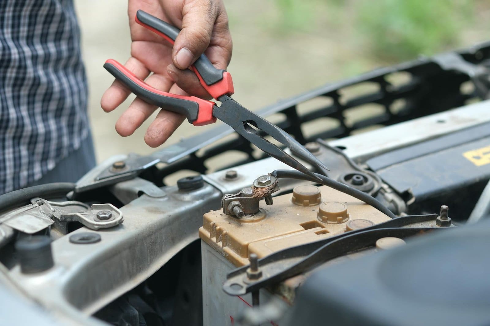 a person holding red and black hand tool